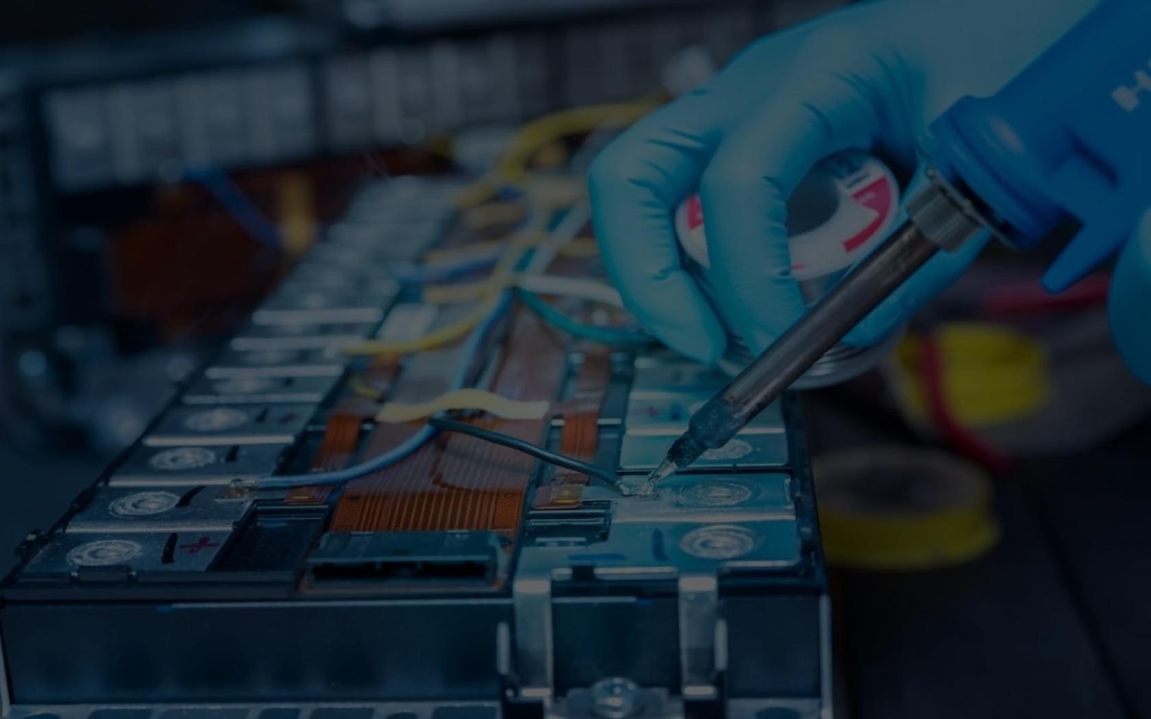 A technician soldering cell connections on a lithium-ion battery pack at the Humaya Power workbench